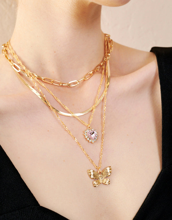 Set of 4 charm necklaces with butterfly and heart designs on a woman's neck, Extension chain for customised fit, Crafted from polished zinc alloy.