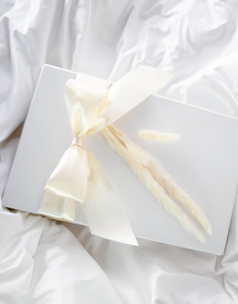 Standard size white box with V flap magnetic lid wrapped in champagne satin ribbon