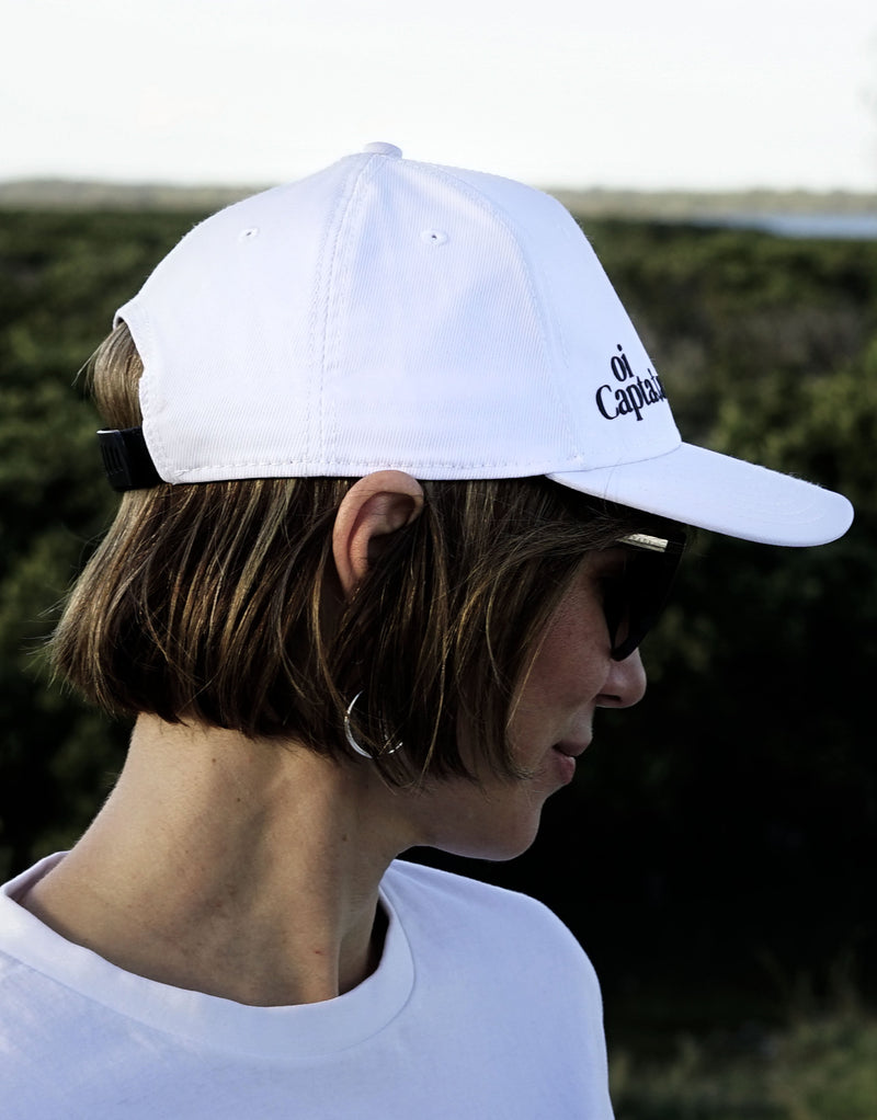 The Oi Captain Endless Summer Cap will quickly become your new favourite for any outdoor activity.  Made with an adjustable band back, structured front panel, and quality made finishes for total comfort. Unisex, one size fits All.  Stay protected in style with this on-trend classic cap.